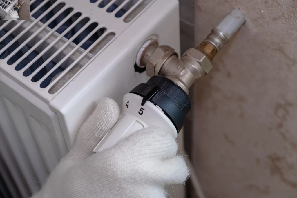 hand in glove turns the heating regulator