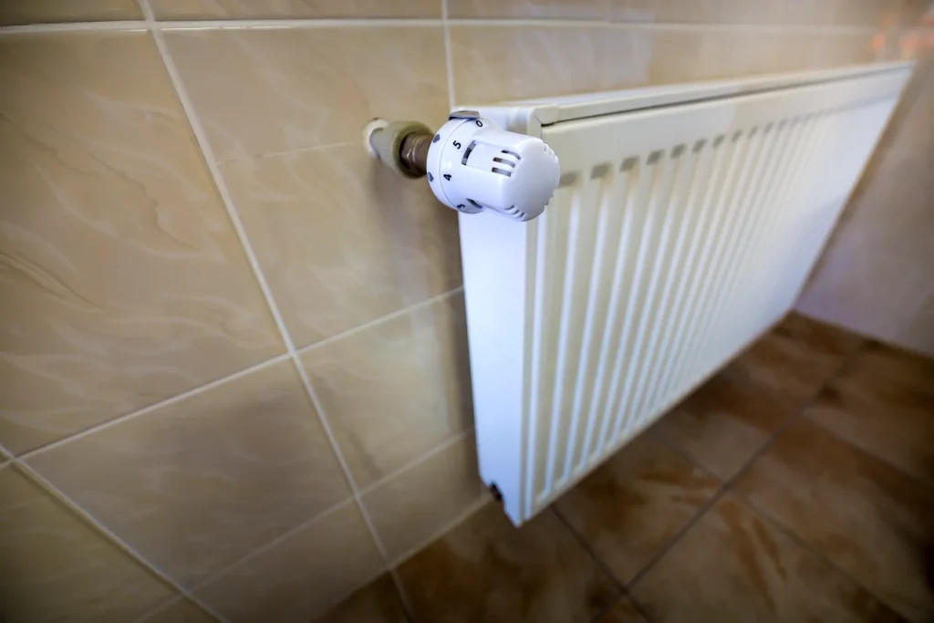 close up of white heating radiator with thermostat