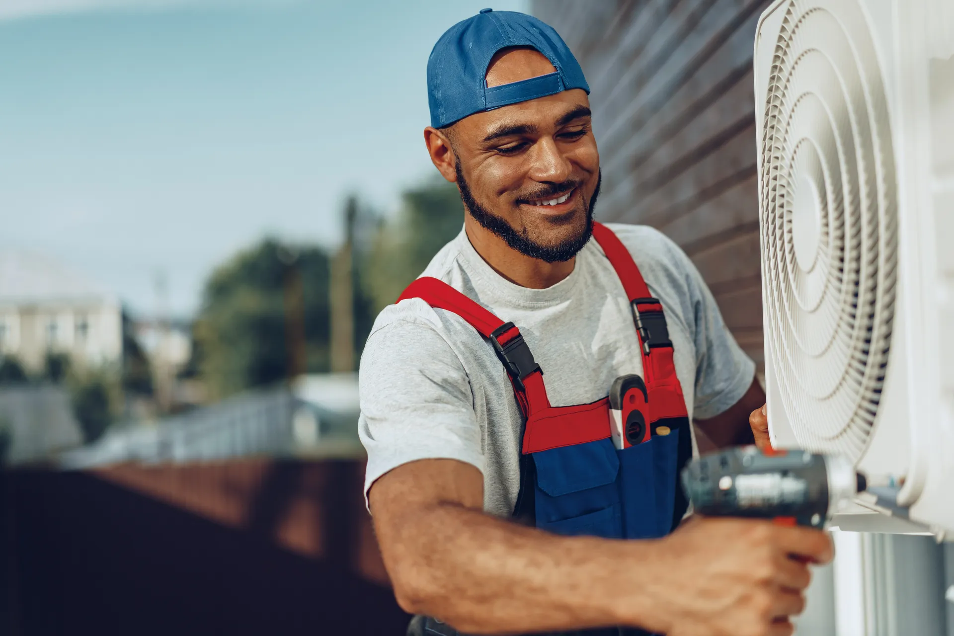 repairman in uniform installing the outside unit